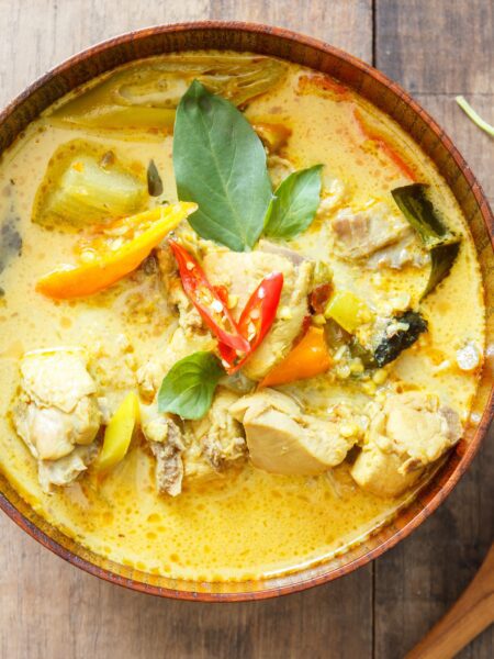 Thai Chicken Curry served in a bowl with wooden spoon on the side